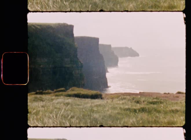 Sea coastline with meadow and mountains during the day