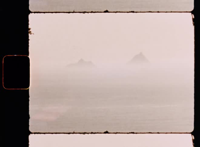 Two islands under mist in the horizon caught on vintage film