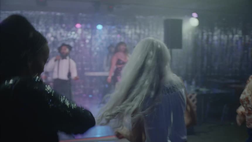 A group of people dancing on the dance floor of a nightclub