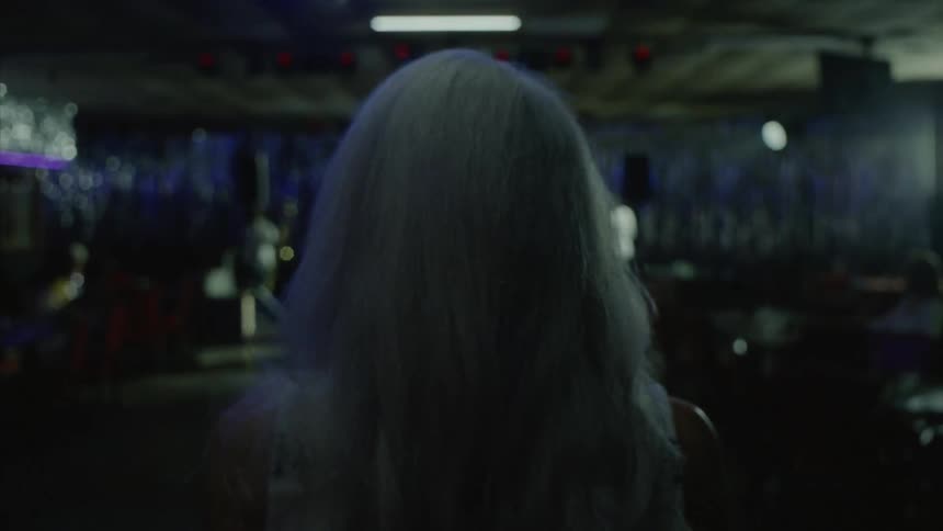 Woman with her back walking inside a club