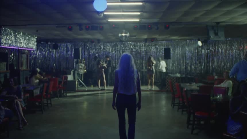 Woman with withe hair walks into a night club