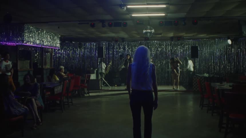 A person walking up to some people with musical instruments
