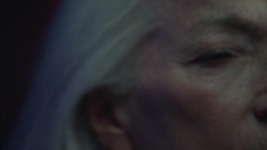 Woman with gray hair dancing in a club then suddenly stopping and closing her eyes