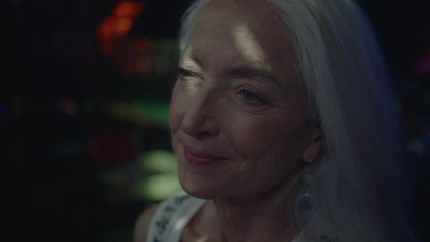 An old woman shaking her head happily