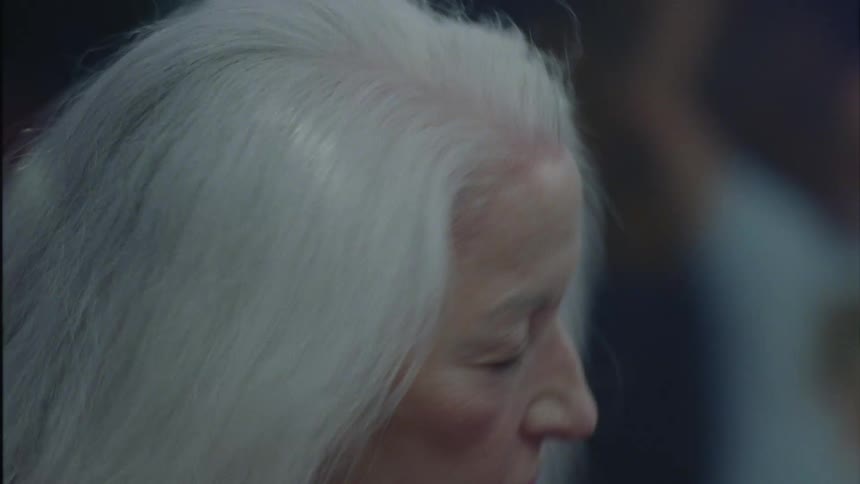 Mature woman with gray hair dancing in the club