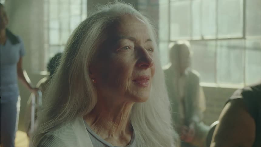 An elderly woman with other elderly indoor