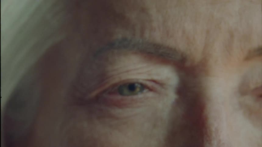 Portrait of an elderly woman opening her eyes in a room