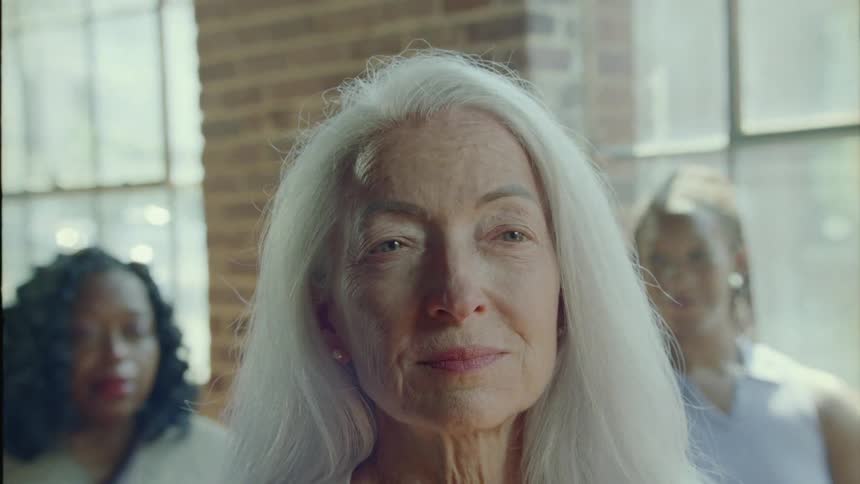 Portrait of an elderly woman shaking her head slightly and with a happy facial expression
