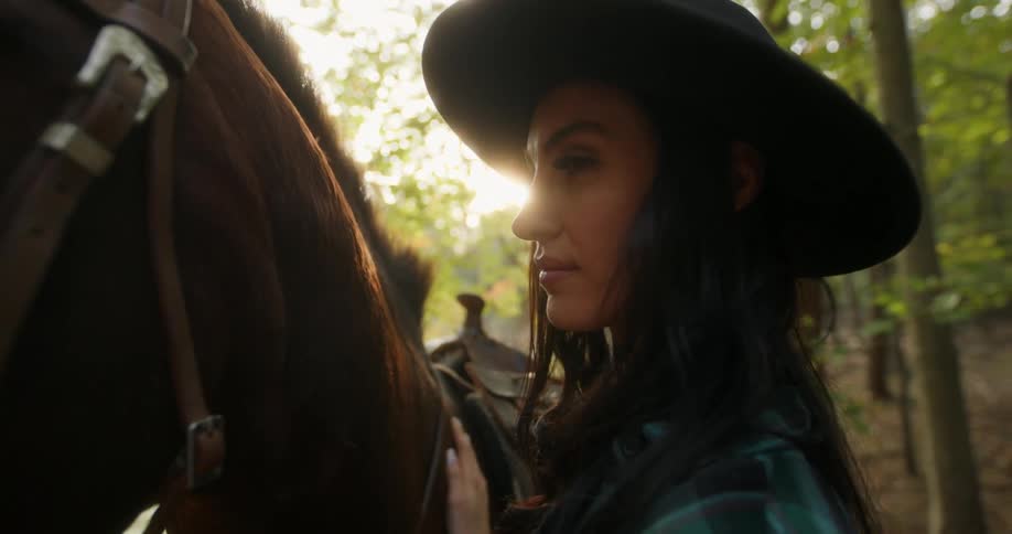 A woman petting a horse in the forest