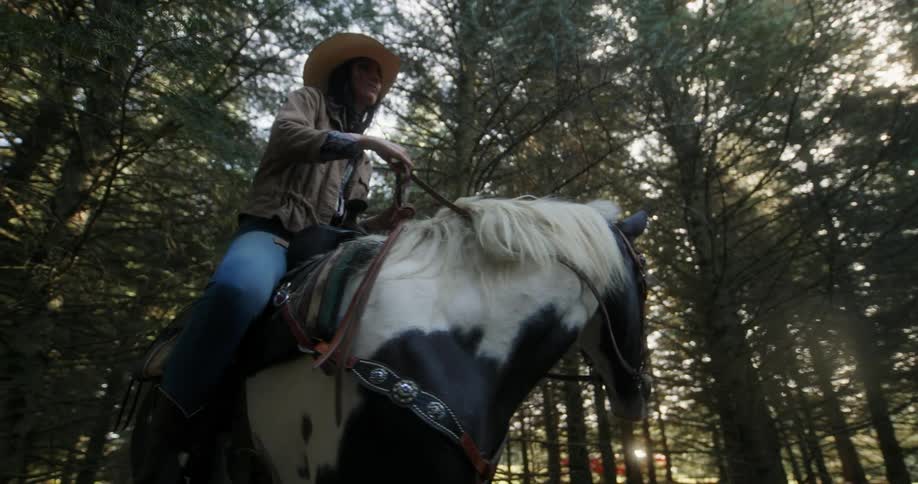 A woman is riding a horse in the forest