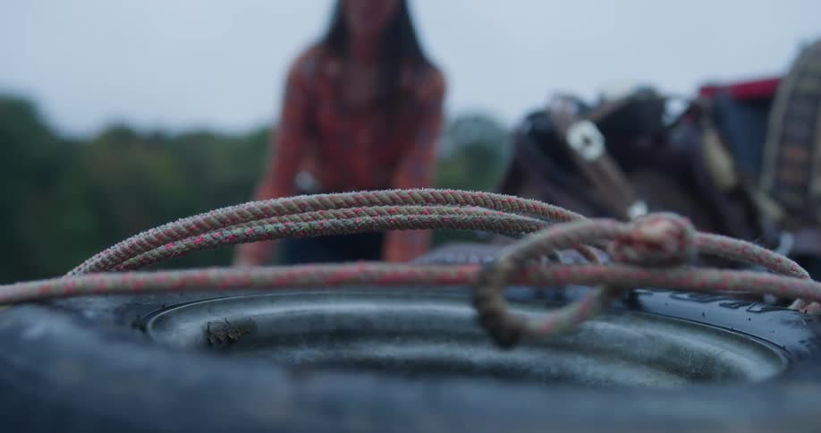 Lady dropped a rope at the back of a pickup truck at midday