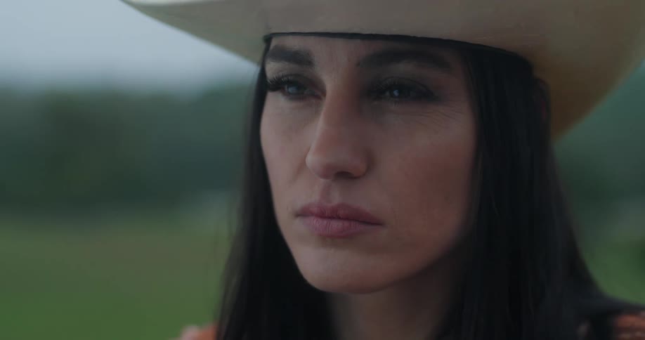 Closeup of a womans face wearing a cowboy hat