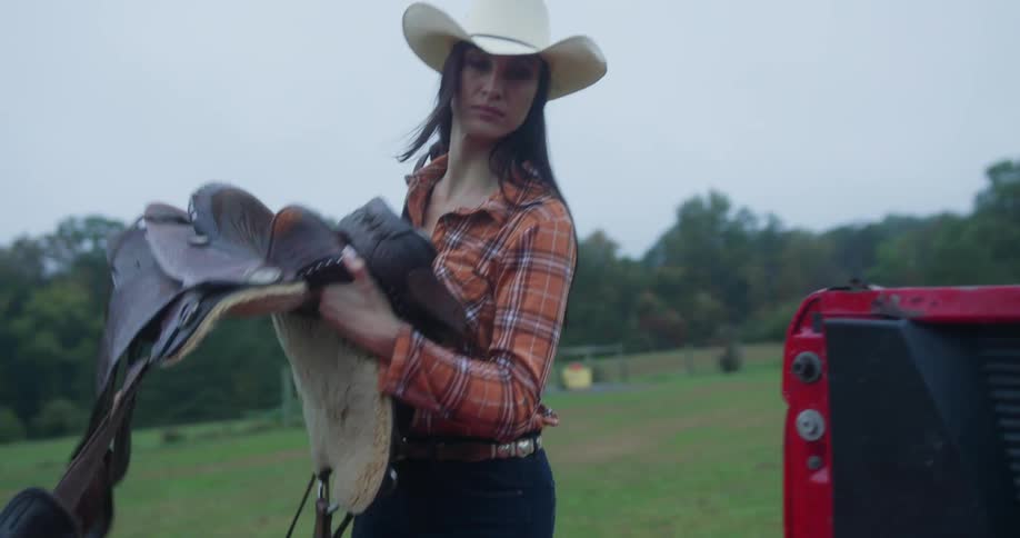 Cowgirl taking a horse seat and putting it in the car