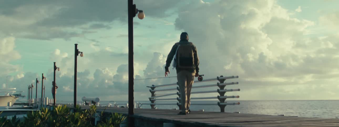 Fisherman walking on a pier at morning