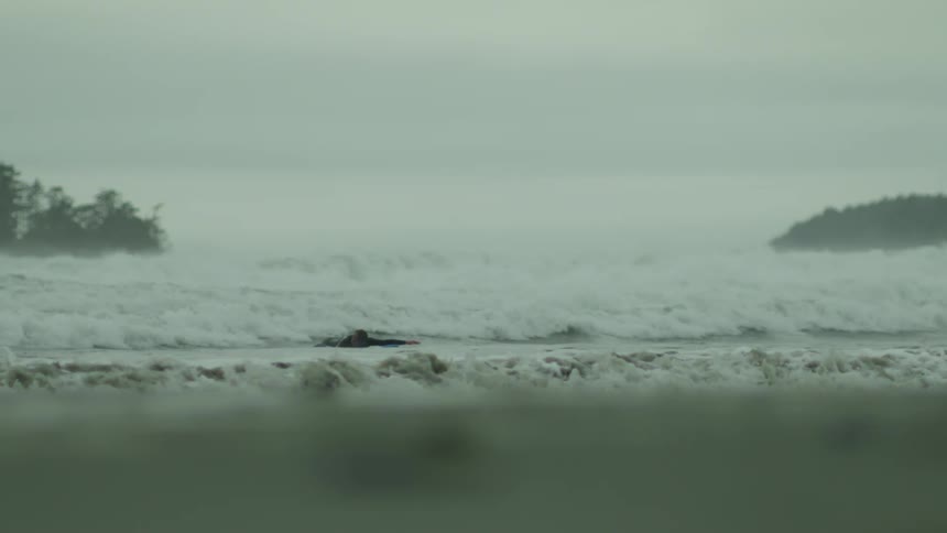 A man is surfing by the shore