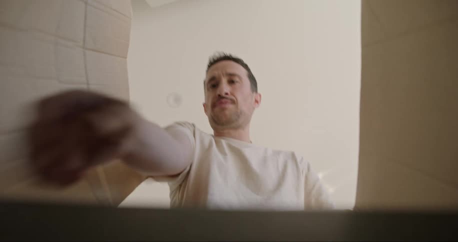 A man opening a cardboard box and taking out a cup