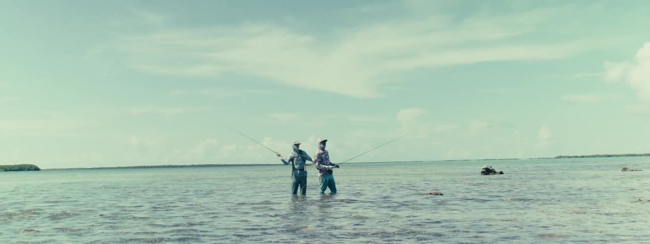 Two men fishing standing in the sea during the day