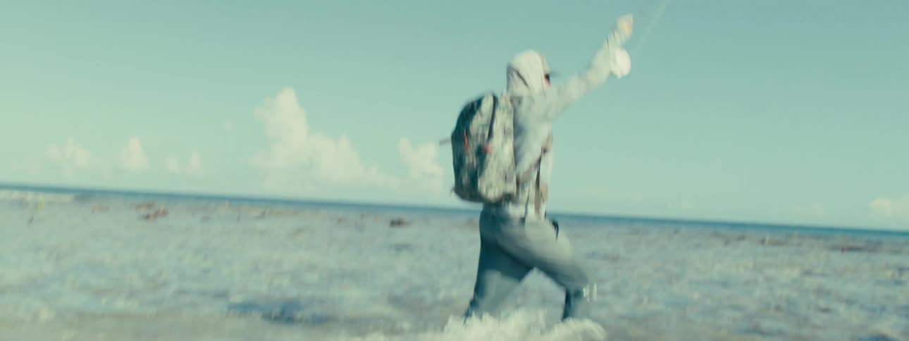 A man fishing on a beach with clear waters
