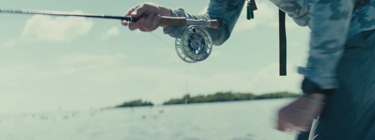 Man pulling the fishing line in shallow waters at sea