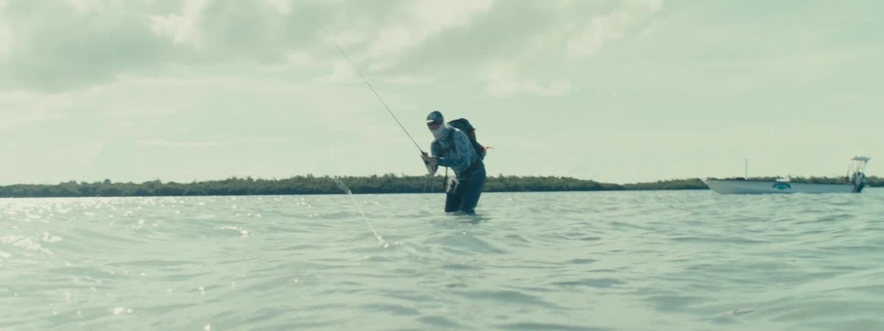 A man in the sea fishing at high tide
