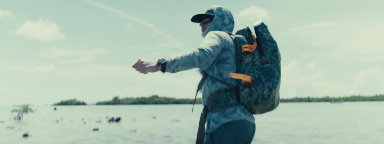 A man holding a fishing rod is preparing to throw it into the water