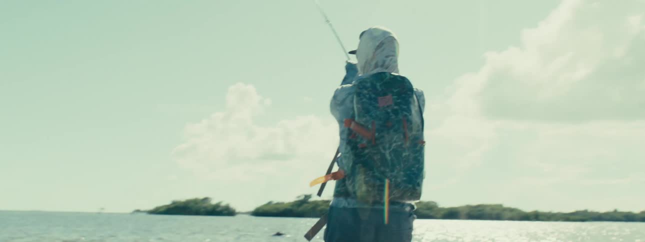 A person fishing at the seashore during the day