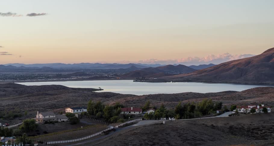 Aerial view of a rural city with a lake and mountains as backdrop