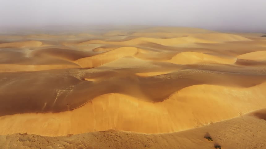 Aerial of dune desert with fog during daytime