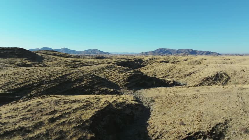 Aerial panorama of a landscape with plateaus and mountains under a blue sky