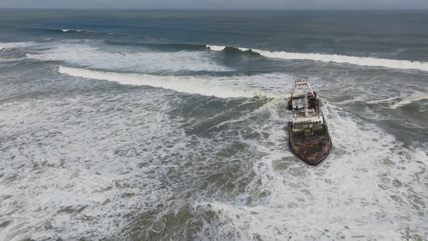 Ship stranded at sea with waves passing under it