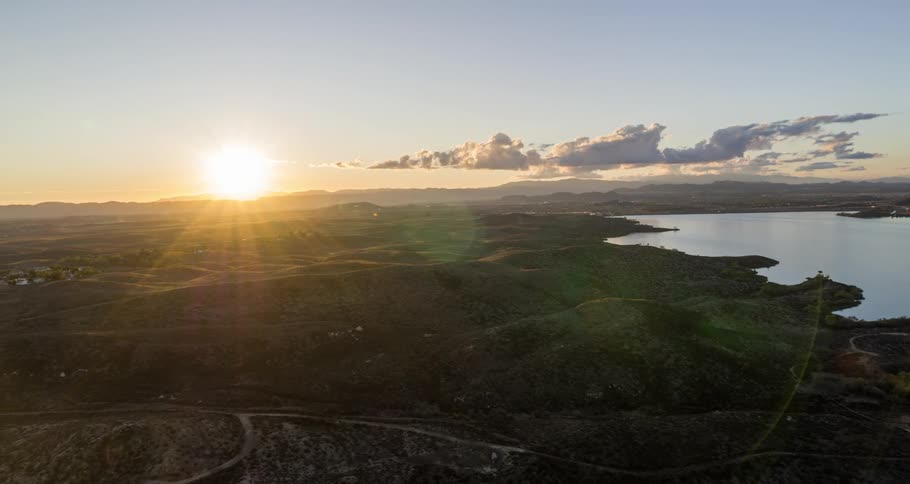 Rising sun shines across terrain crossed by a network of roads
