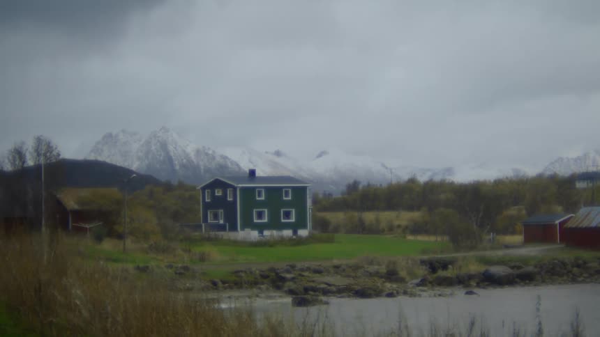 House in a rural area with snowcovered mountains on the horizon