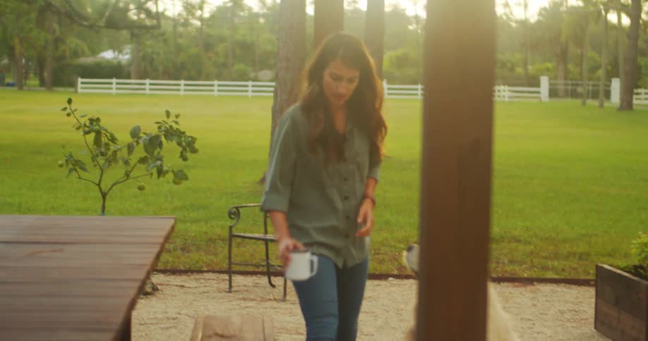 Woman walking sitting on an outdoor bench and petting her dog