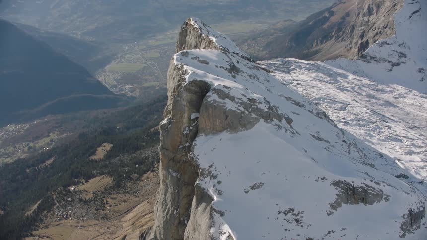 Aerial panorama of snowcovered cliffs under mountains