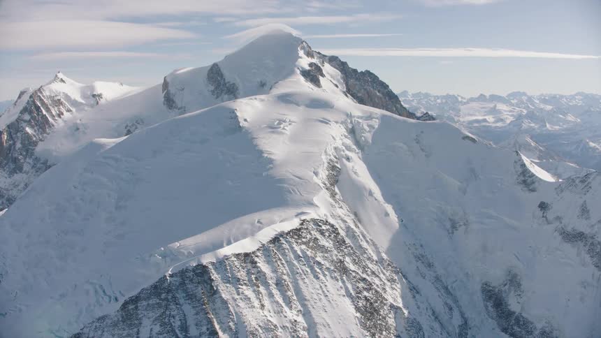 Aerial of mountain covered in ice and snow during the daytime