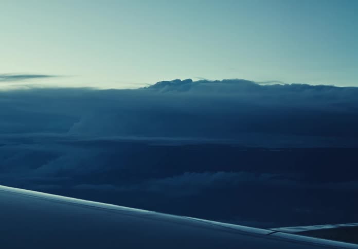 The plane is flying high above the storm clouds