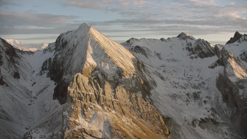 Aerial view of sunlight on the slopes of a snowy mountain