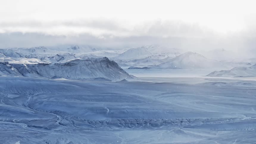 Aerial of the plain and mountains with snow on the peak