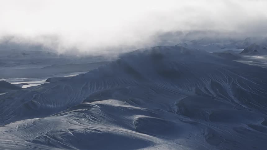 A mountain in a region with snow on the surface and a large cloud in the sky