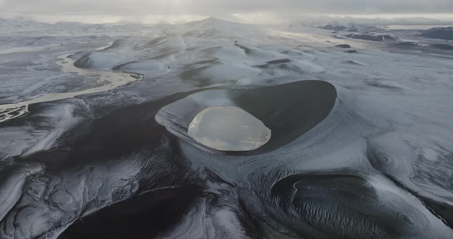 River winds past lake filled craters in volcanic terrain