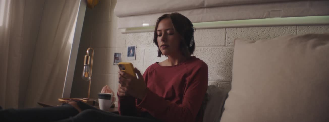 A girl is listening to music on her cell phone