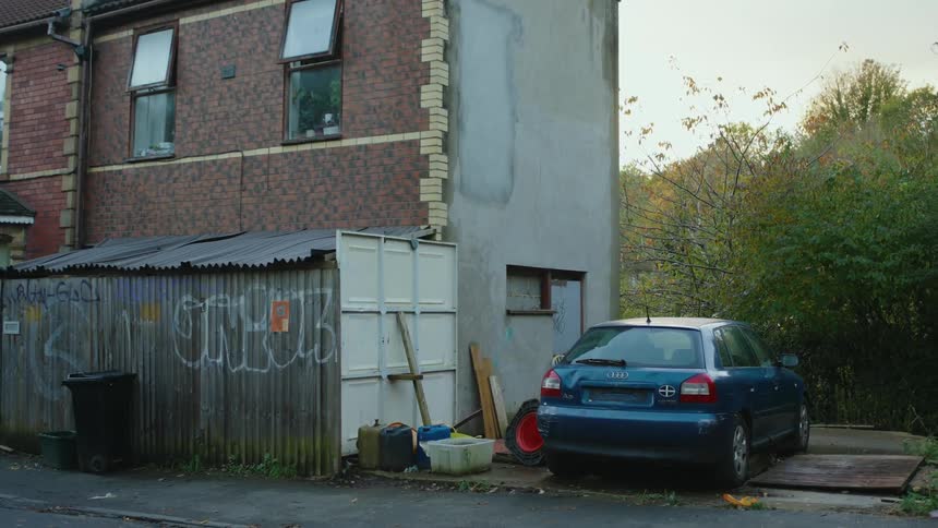 Graffiti covers fence behind apartment buildings