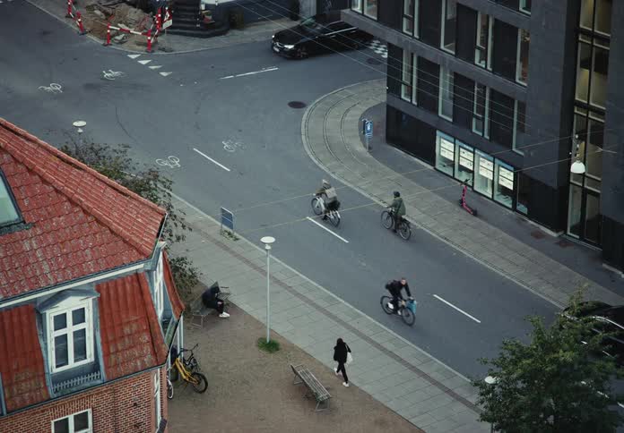 People are riding their bikes and driving their cars in the city