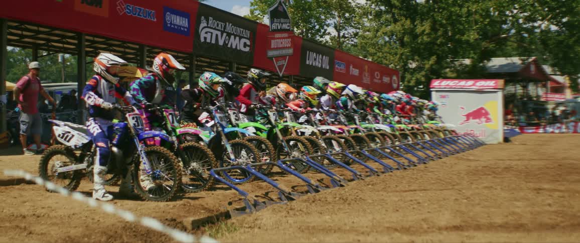 People in a motocross competition on a dirt road