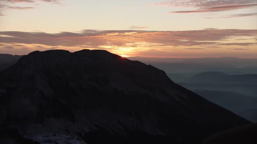 Aerial of snowy mountain top during dawn