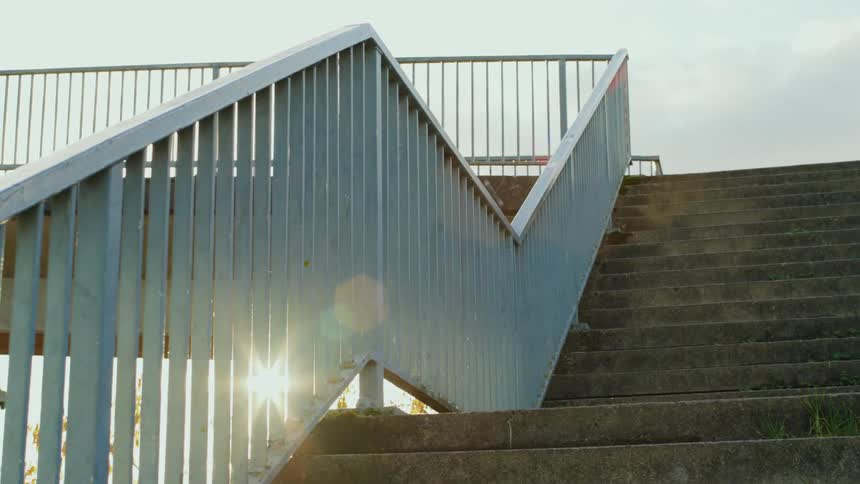 Stairs on a concrete walkway with iron handrails