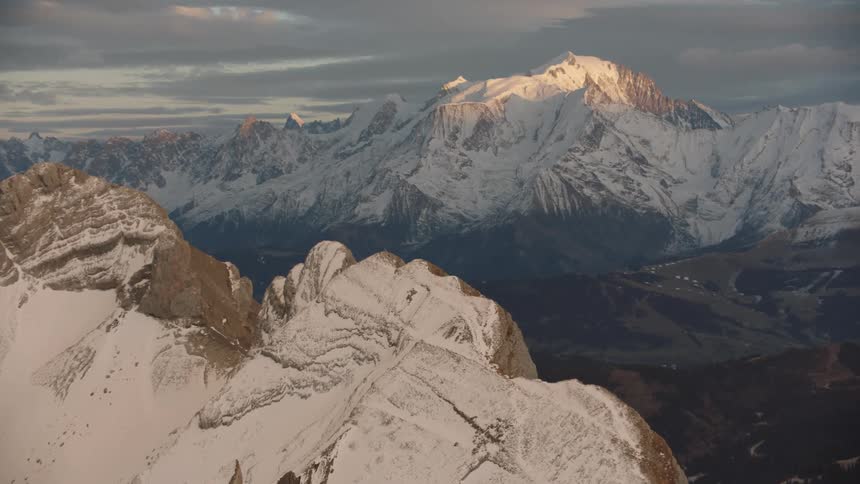 Aerial of a mountain peak with snow during dawn
