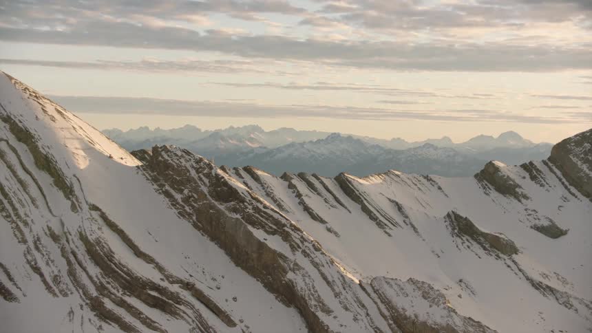 A jagged and rocky mountain range is covered in a layer of snow