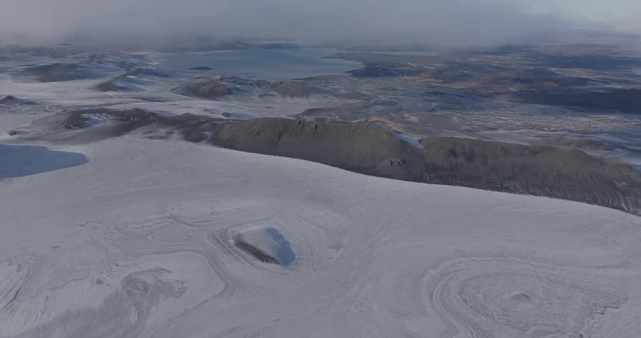 Aerial of mountains and plains with frozen lake