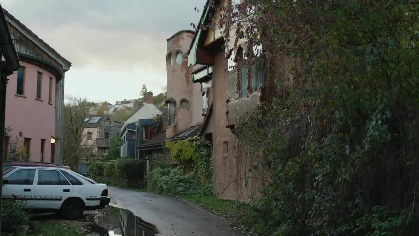 View of a narrow street in a residential neighborhood with greenery